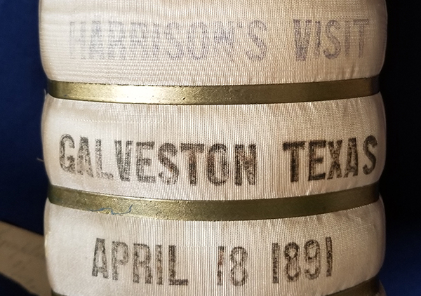 This small bale of cotton was presented to Mrs. Harrison during a Presidential visit to Galveston, Texas, April 18, 1891. It is covered on all sides with a grosgrain silk fabric, but the fabric comes around the two wide sides partially leaving a small 