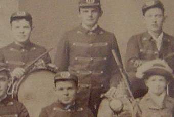 Photograph of five union soldiers during the civil war, including a drummer boy. There is also a woman gathered in the photo.