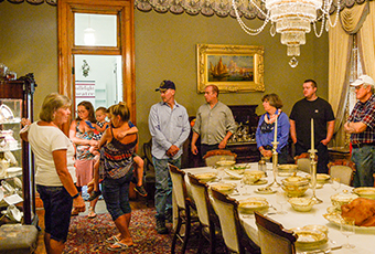 Image of a female docent with visitors in the dining room of the Harrison home.