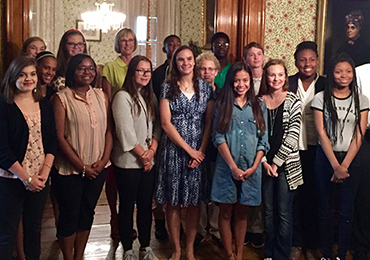 Lieutenant Governor Suzanne Crouch poses with students in the back parlor of the Harrison Home.