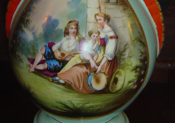 Porcelain blue vases, gold trim and orange-red handles. Hand painted street scenes with child on man's lap and woman holding grapes. Wedding gifts from Mrs. Harrison's father, John W. Scott, to Mrs. William Bridges about 1874-75.