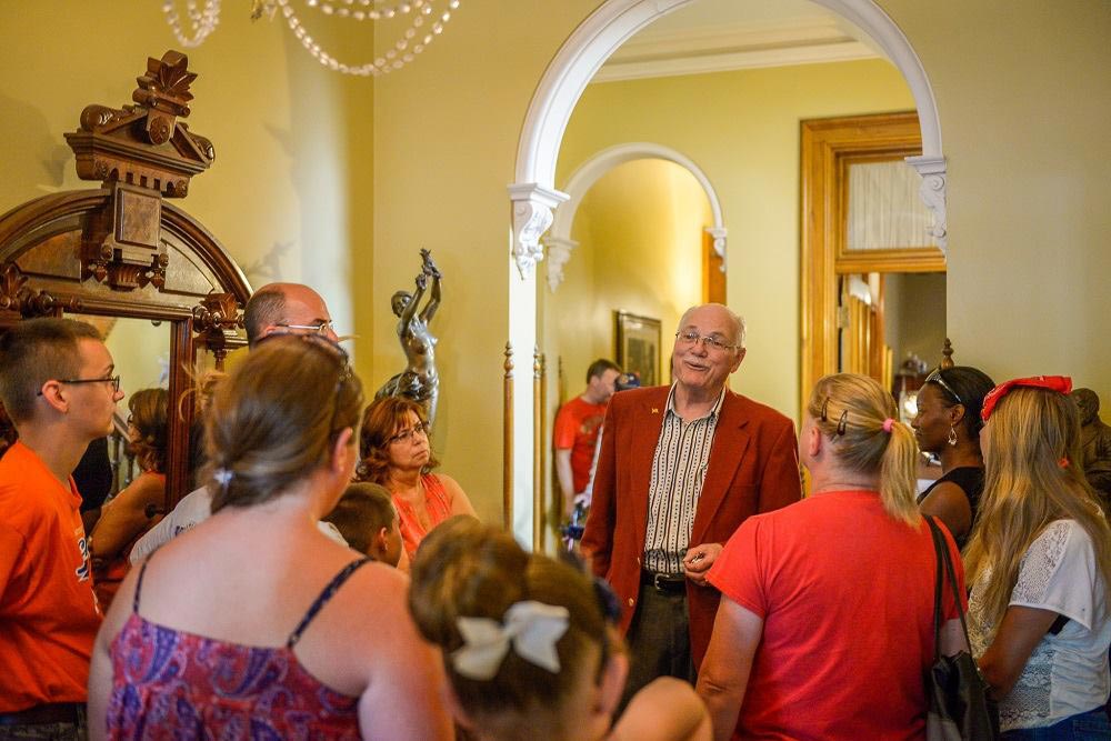 Photograph of a docent leading a small tour through the halls of the presidential mansion.