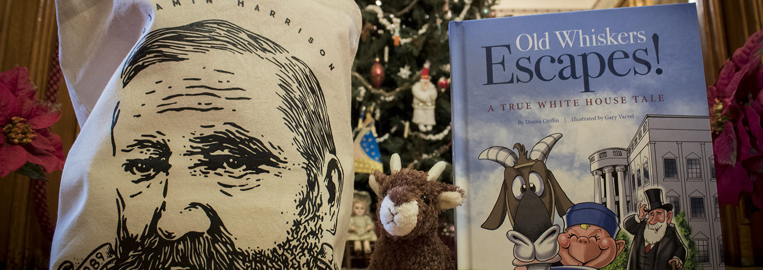 This photograph features Benjamin Harrison merchandise, including a tote bag sporting an illustration of Benjamin Harrison's face, a plush of Benjamin Harrison's pet goat, Old Whiskers, and a children's book about Old Whisker's escape.
