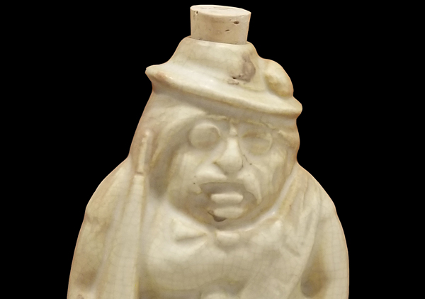 Ivory colored flask that depicts Teddy Roosevelt wearing sash that says 