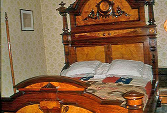 Original Harrison large rosewood and satinwood Renaissance Revival bed. Satinwood panel in tall head board. Large Egyptian medallion in center of head board that matches smaller medallions in chairs. The head board is 8 feet tall with squared feet. Squared urn design on foot board. Foot board has round massive legs. Ornamental pieces in medallions, scrolls, etched designs, etc.