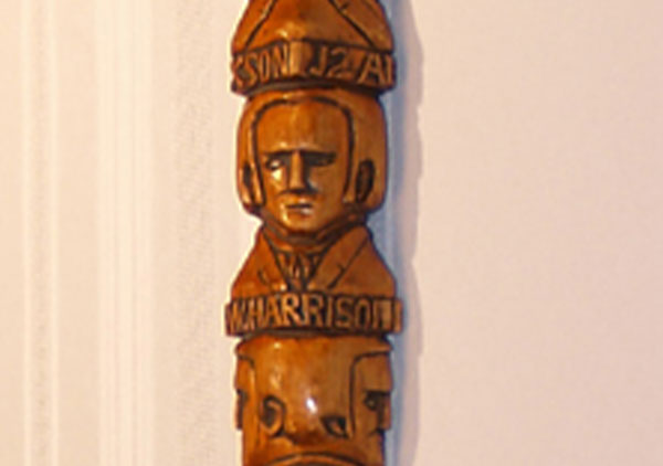 Centennial walking stick, contains hand carved images (head and shoulders in relief) of all the Presidents from Washington to Benjamin Harrison with name below each. They are on both sides of the cane coming down to Harrison. Wood is white pine and stained. The carved handle is an animal head design. Three of the president's names are misspelled: Madison, Hayes, and Arthur.