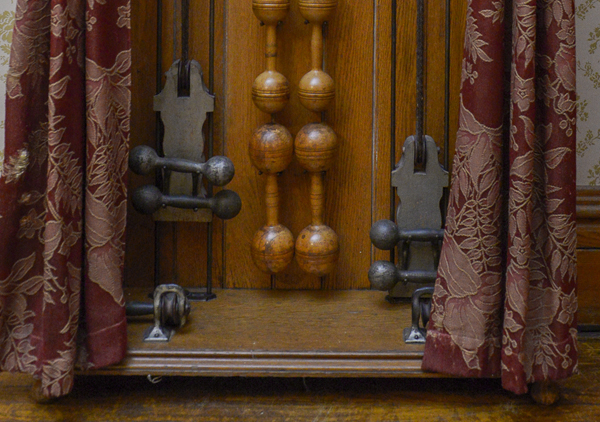 Oak case with iron dumbbell shaped weights (5) on ropes to be pulled, eight sets of wooden dumbbells and pair of Indian clubs. Metal plate: 